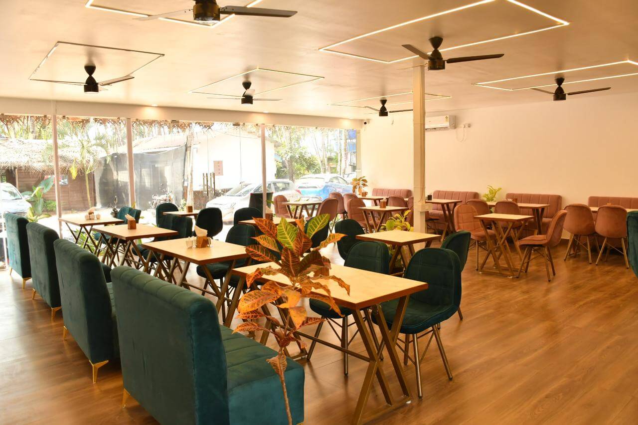 Elegant dining area in Escape Goa's resort restaurant, featuring a warm ambiance and a menu of delectable multi cuisine dishes.